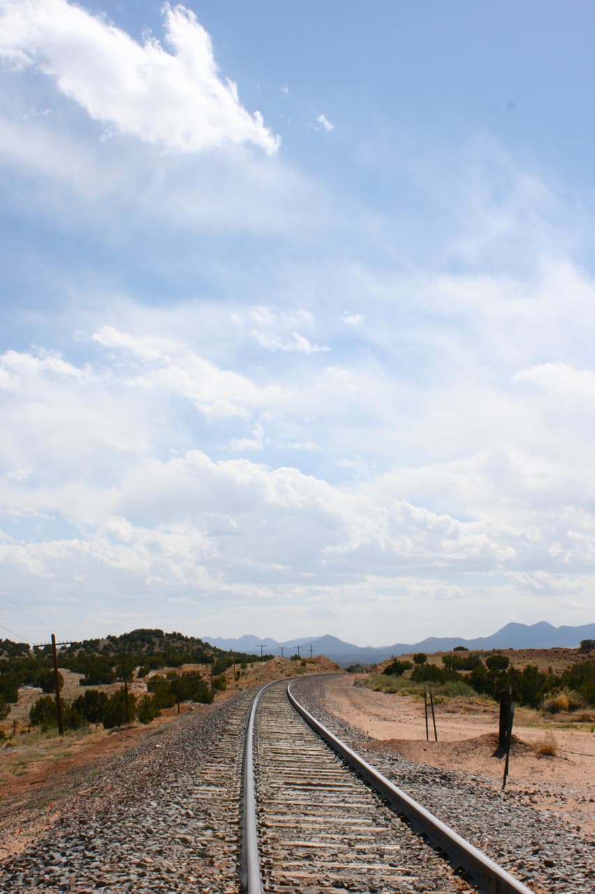 View of the small village of Galisteo, New Mexico, with adobe buildings against open high-desert land.